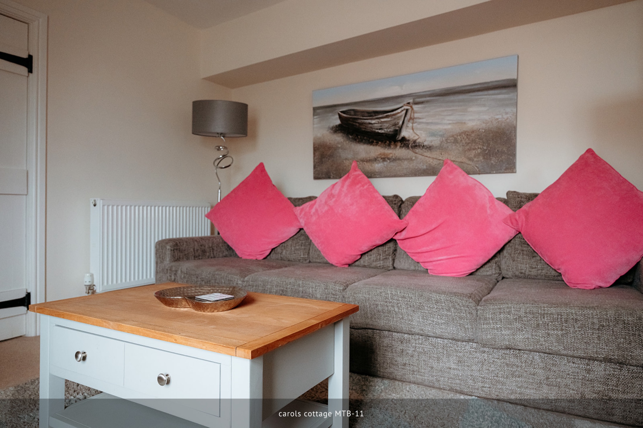Living room with sofa, pink cushions and coffee table