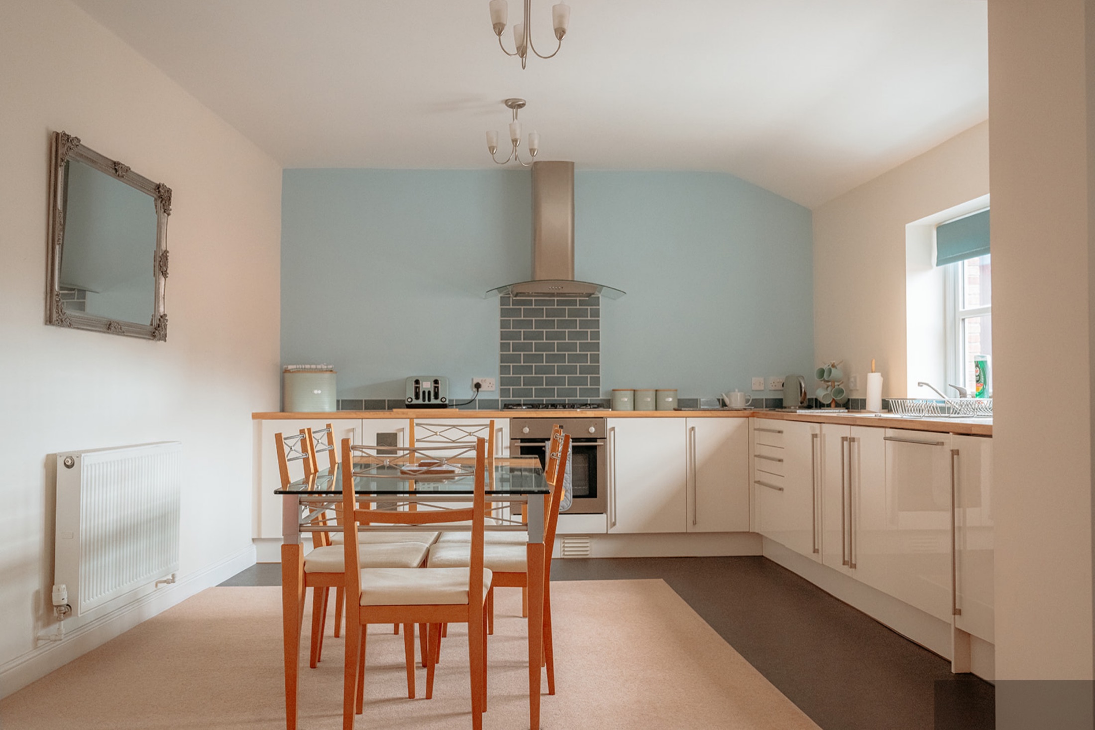 Kitchen with blue splashback and wooden worktop